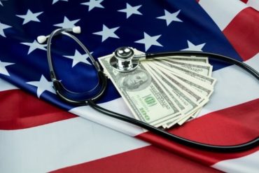 decorative image of american flag with stethoscope and several U.S. currency