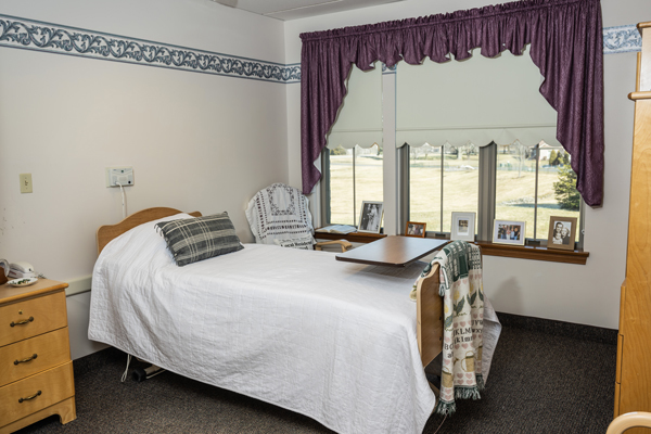 Single bed in a skilled nursing room with a dresser