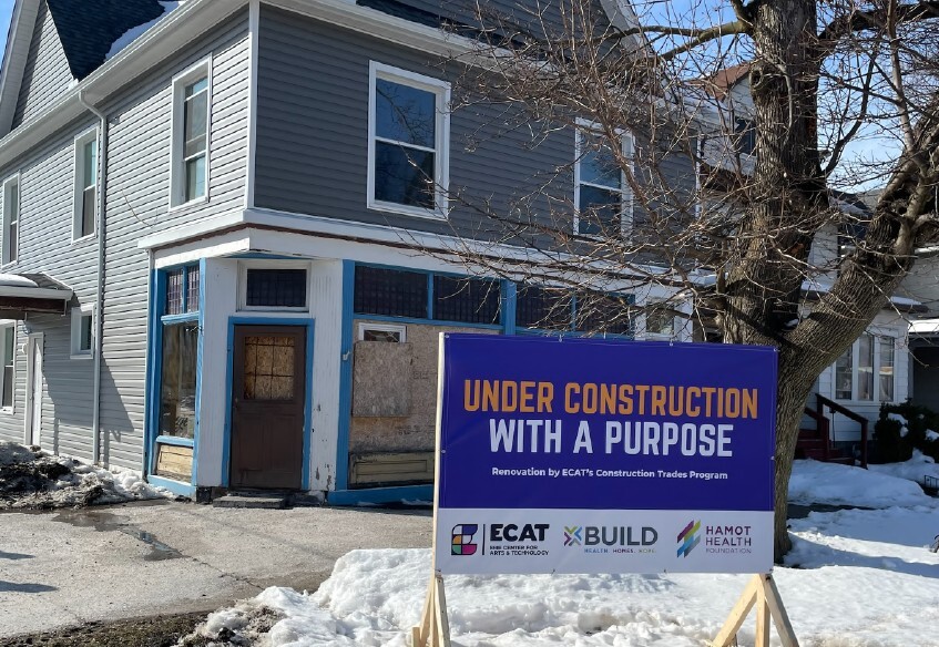 Under Construction with a Purpose Sign in front of a house