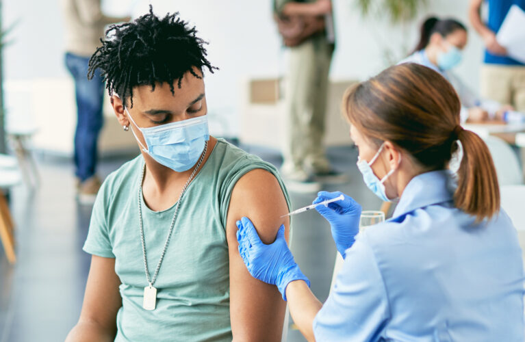 Nurse giving a male a shot in the arm