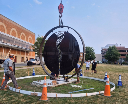 Lowering sculpture to slab with crane
