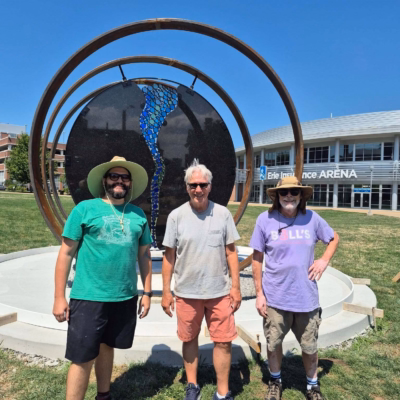 Looking Glass Artists in front of sculpture