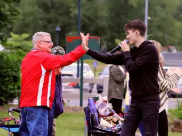 Father John Detisch, pastor of Saint Tobias Parish, high fives one of The Scally Brothers during their concert