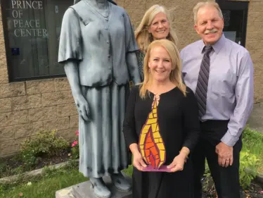 Lisa Louis, Catholic Foundation executive director, with Prince of Peace Center's executive director Joseph Flecher and board member Lisa Dach