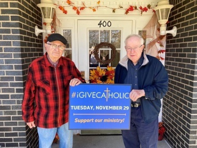 Father Leo Gallina (left) and Monsignor Robert Smith (right) holding their #iGiveCatholic sign outside of the Bishop Michael J. Murphy Residence for Retired Priests