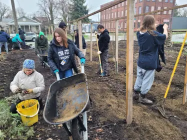 Teenagers and Garden Coaches planting seeds for Farmers Market at their Urban Garden