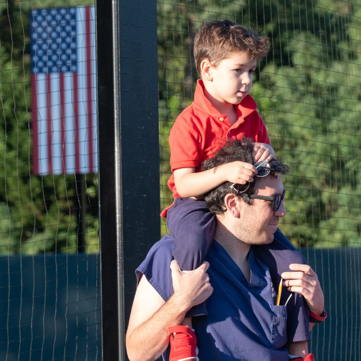 Dad with son on his shoulders with American Flag