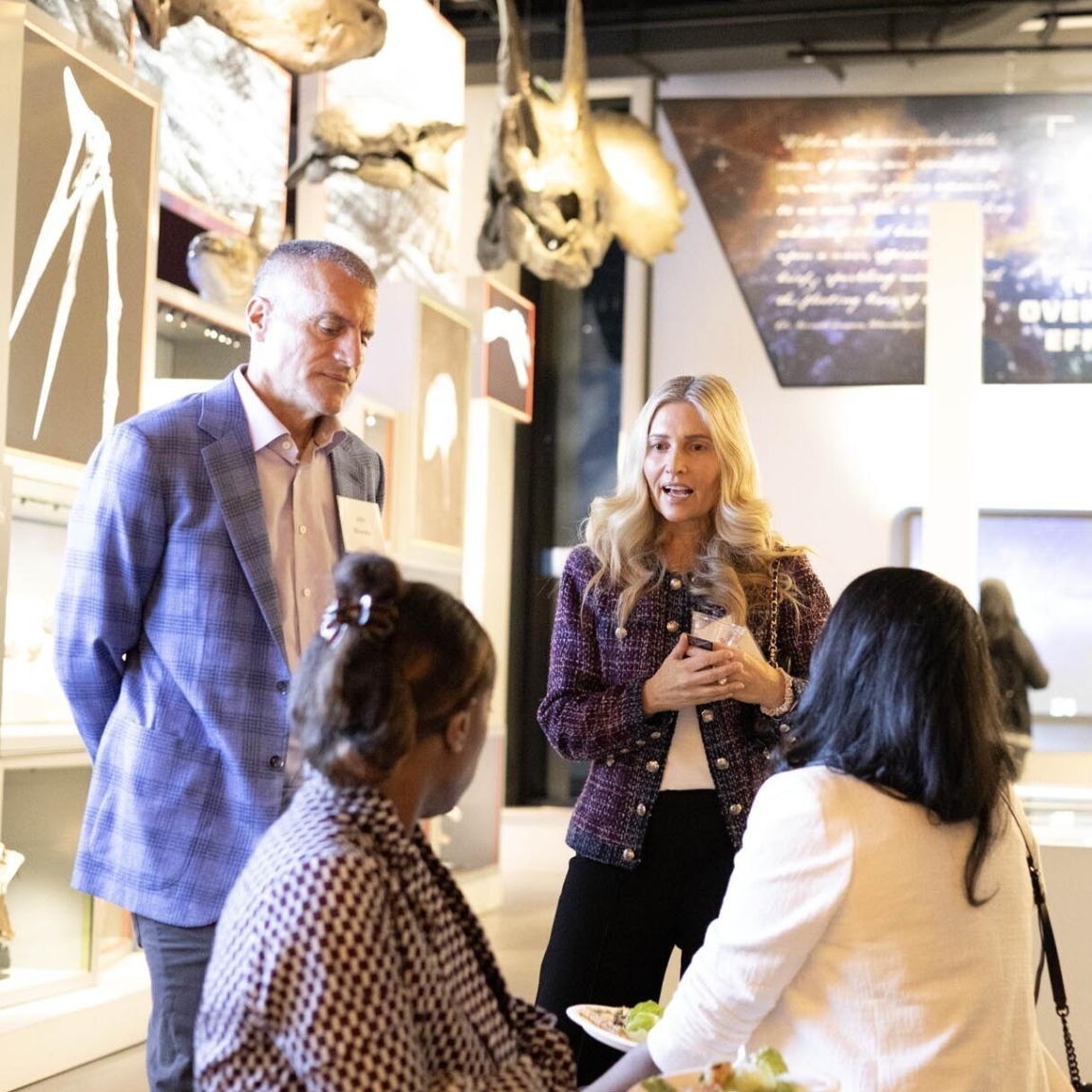 Four people talking in a museum setting