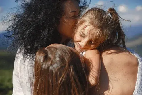 mom with two daughter hugging